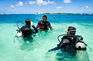 An instructor teaching new divers in shallow water